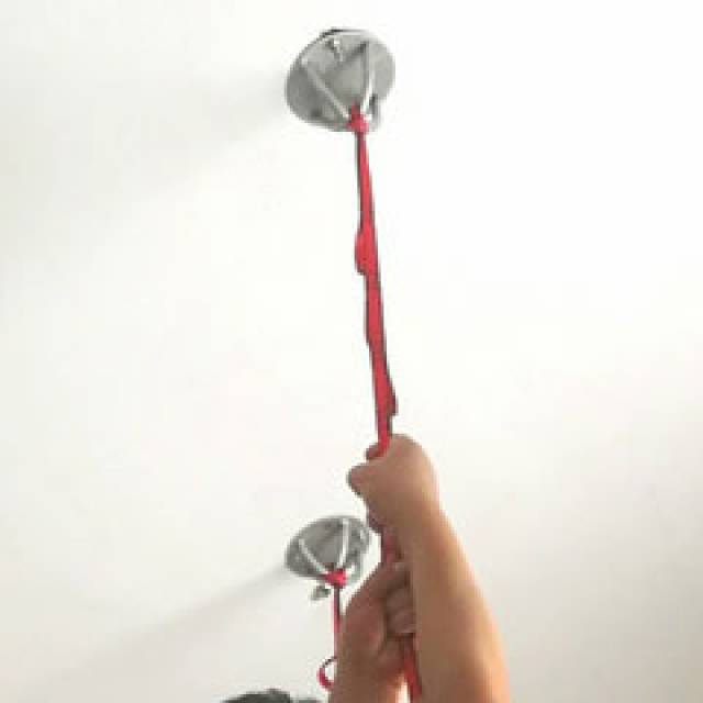 Anchor plate fixed to a ceiling with a red strap hanging from it