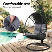 Black wicker egg chair by a pool, showing the armrest and the 8cm thick padded seat