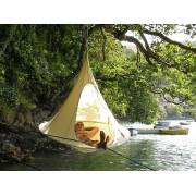Natural white Cacoon single hung from a tree beside a river