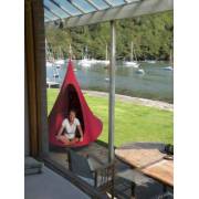 Person sitting in a red Cacoon single on a deck overlooking boats