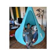 Woman sitting in a turquoise Cacoon single in a living room