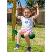 Girl sitting on a green swing seat beside a timber post, holding the ropes