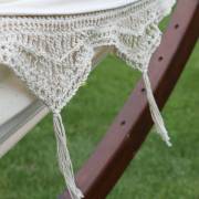 Close up of the crochet fringe and tassels over the dark wood stand