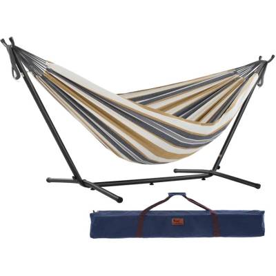 Beige and grey striped cotton hammock on a black steel stand with its carry bag, on white