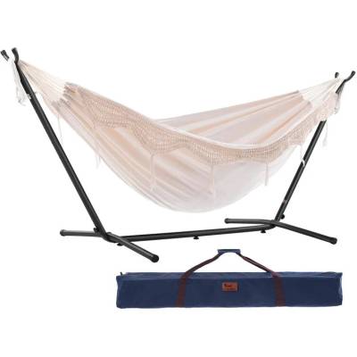Beige cotton hammock with fringe on a black steel stand with its carry bag, on white