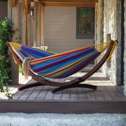 Mixed bright colours hammock on its wood arc stand on a timber deck