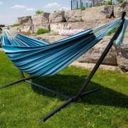 Mixed blues hammock on its steel stand on a lawn beside a rock wall