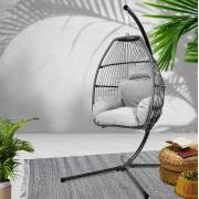 Grey open weave egg chair on a rug in a bright room