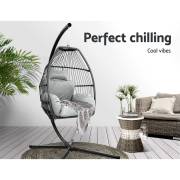 Grey open weave egg chair on a verandah beside a wicker lounge