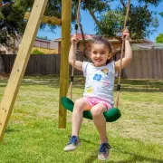 Girl smiling on a green swing seat