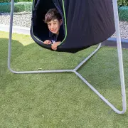 Boy leaning out of the cocoon doorway, with the cocoon on its steel frame