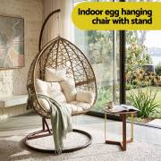 Latte rattan egg chair indoors beside a window and a side table