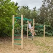 Child hanging from the monkey bars in a backyard