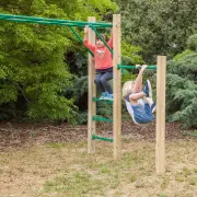 Two children hanging from the monkey bars