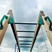 Looking up at the monkey bar rungs between the two timber beams