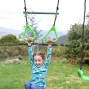 Girl hanging from the green trapeze rings