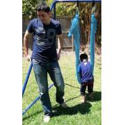 Man and boy standing beside the teal wrap swing on the swing set stand