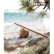 Natural rope hammock hung from a pandanus tree on a beach