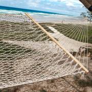 Natural rope hammock hung between trees on a beach