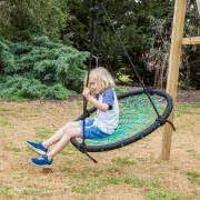 Boy swinging on the web swing, holding the ropes