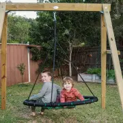 Two boys sitting on the web swing under the timber frame