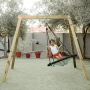 Girl sitting on the 120cm web swing under the timber frame in a courtyard