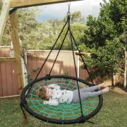 Toddler lying back in the web swing