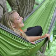 Woman lying in the green and grey parachute hammock