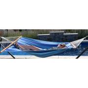 Woman lying in the mixed blues spreader bar hammock beside a pool