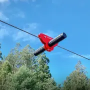 Red Woomera trolley with its handlebar running on the flying fox cable