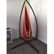 Red and yellow pod chair on the X stand in a bedroom