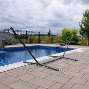 Charcoal steel spreader bar hammock stand beside a pool
